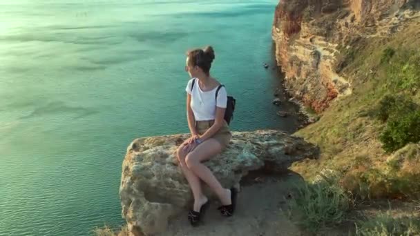 Girl on a cliff cliff near the sea — Stock Video