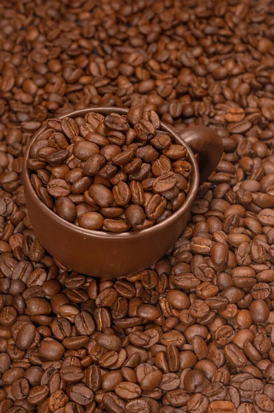 Koffiekopje met koffiebonen op een achtergrond van koffiebonen — Stockfoto