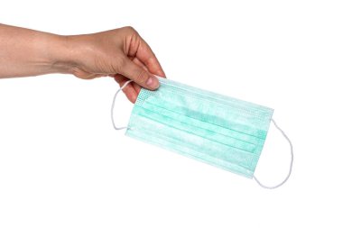 Kadın elleri grip ve virüslere karşı koruyucu bir maske tutuyor.