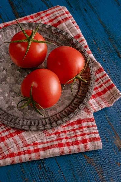 Verse tomaten in rustieke stijl op een blauwe houten achtergrond — Stockfoto