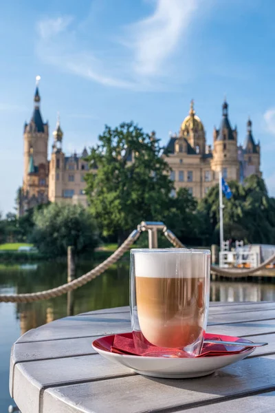 Kupa cappuccino egy gyönyörű kastély Schwerin a háttérben. — Stock Fotó