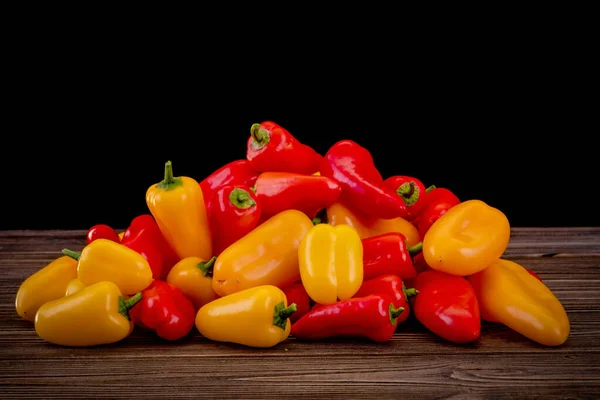 Fresh colored bell peppers on a rustic wooden background. — Stock Photo, Image