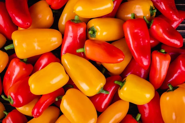 Fresh colored bell peppers on a rustic wooden background. — Stock Photo, Image