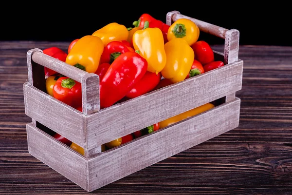 Fresh colored bell peppers on a rustic wooden background. — Stock Photo, Image