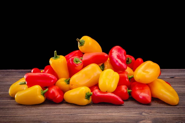 Fresh colored bell peppers on a rustic wooden background. — Stock Photo, Image