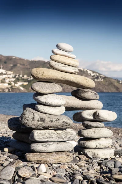 Rock balancing or stone balancin,  naturally balanced on a beach with the sea behind