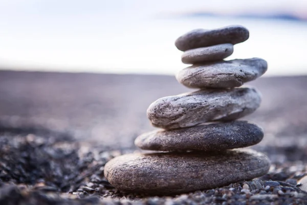 Rock balancing or stone balancin,  naturally balanced on a beach with the sea behind