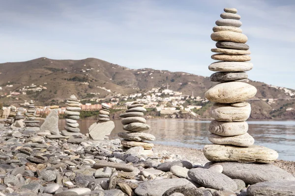 Rock balancing or stone balancin,  naturally balanced on a beach with the sea behind