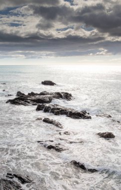 taşlı bir plajda dalgalar kırma