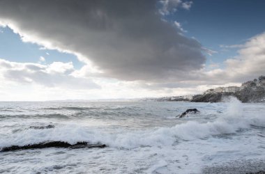 taşlı bir plajda dalgalar kırma