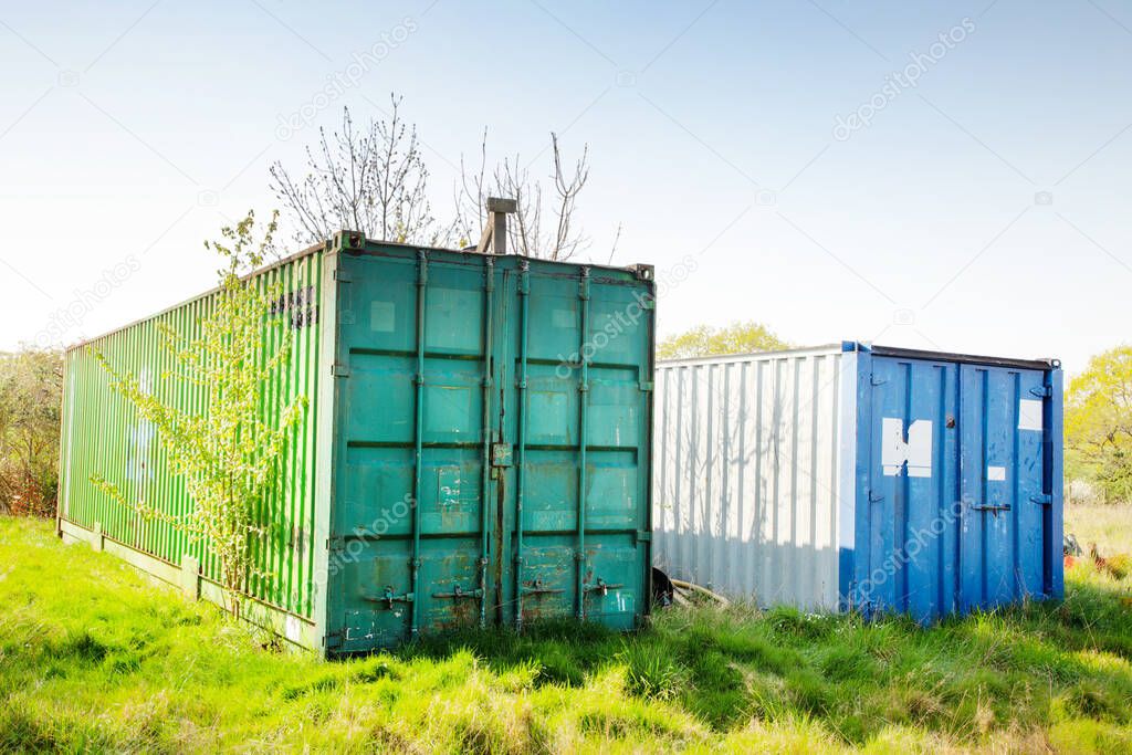 large metal shipping containers in a field