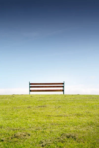 Одинокая Скамейка Траве Против Голубого Неба — стоковое фото