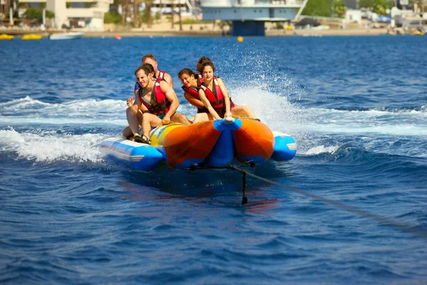 エイラート イスラエル 2017 海の魅力 日当たりの良い夏の日に乗ってバナナ ボートを楽しんでいる若者のグループです ビーチのウォーター スポーツ — ストック写真