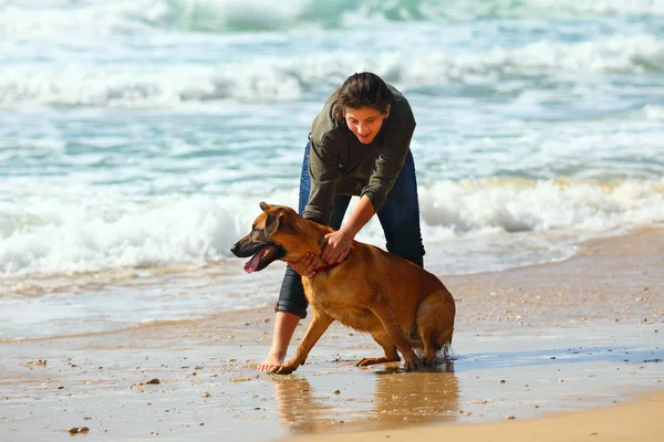 Tonårs flicka med sin hund på stranden — Stockfoto