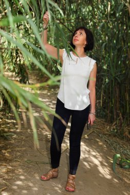 Kamışların çalılığında duran orta yaşlı kadın.