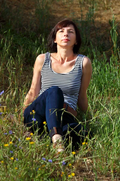Kobieta Średnim Wieku Siedzi Długiej Suchej Trawie Letniej — Zdjęcie stockowe