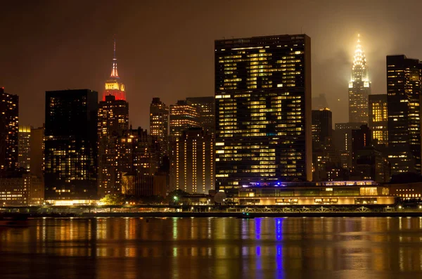 曼哈顿天际线在晚上与反射 美国纽约的摩天大楼 — 图库照片