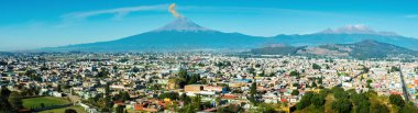 Eruption of Popocatepetl Volcano over the town of Puebla, Mexico, panoramic view clipart