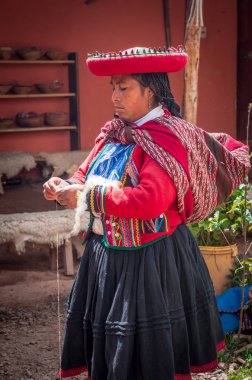 Chinchero, Peru - 9 Mart 2015: geleneksel yöntemlerle ev yapımı yün endüstrisi üzerinde çalışırken geleneksel kıyafetlerini giymiş Perulu kadın