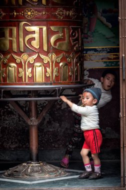 Kimliği belirsiz Nepal çocuklar ibadet tekerlerimi yakın