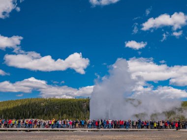 Yellowstone patlayan Old Faithful gayzer izlerken Turistler
