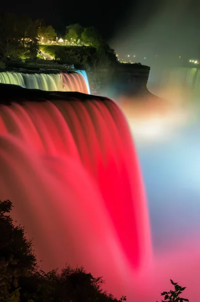Cataratas del Niágara iluminadas en el espectáculo nocturno por luces coloridas. Estados Unidos —  Fotos de Stock