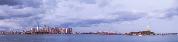 Manhattan skyline y Estatua de la Libertad en la noche con cielo dramático, Nueva York —  Fotos de Stock
