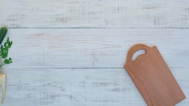 Kesme tahtası ile beyaz ahşap arka planda sebzeler, dur hareketi