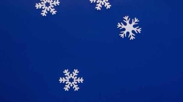 Snöflingor faller på blå bakgrund, stoppa rörelse animation — Stockvideo