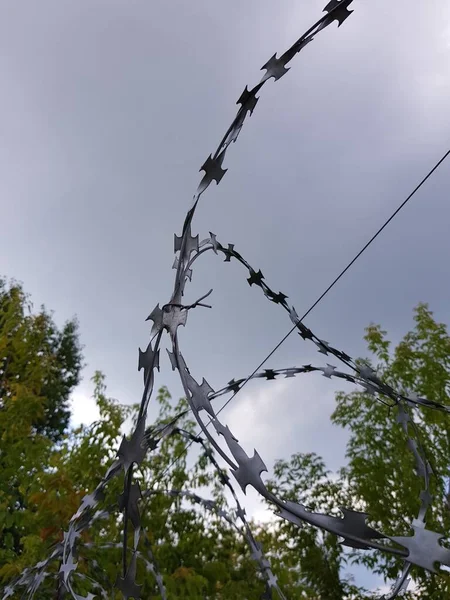 Prikkeldraad Een Hek Tegen Een Bewolkte Lucht — Stockfoto