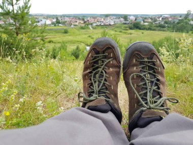 Turist çimenlerde dinleniyor, bacaklarını açıyor.