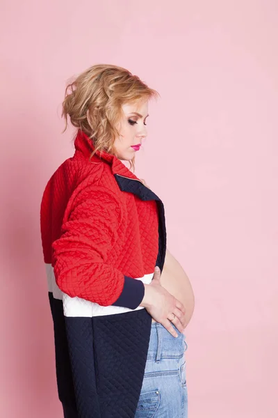ピンクの背景の美しい妊娠中の女の子の肖像画 — ストック写真