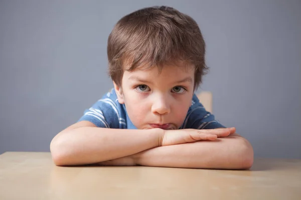 Porträtt Lilla Pojke Barn Sitter Vid Bordet Grå Bakgrund — Stockfoto