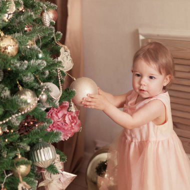 Noel arka plan üzerinde komik mutlu çocuk portresi. Küçük kız ile yeni yıl top oynarken.