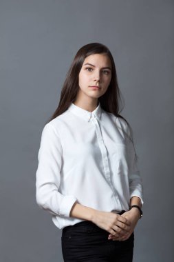 Mutlu güzel kız öğrenci genç gri arka plan üzerinde Beyaz gömlekli portre studio