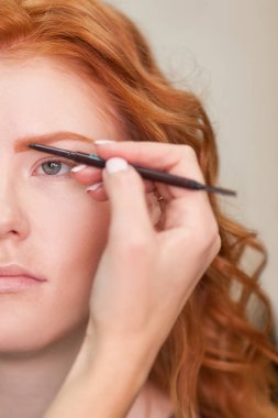 Güzel genç kız bir güzellik salonu düzeltilmesi kaşları var. Kadın düzeltme kaşları formu. Güzel bir kızıl saçlı kız portresi