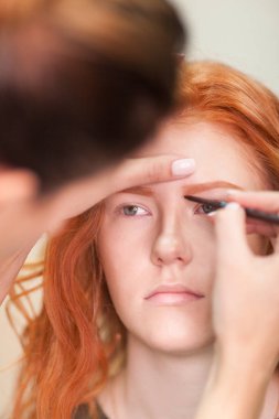 Güzel genç kız bir güzellik salonu düzeltilmesi kaşları var. Kadın düzeltme kaşları formu. Güzel bir kızıl saçlı kız portresi