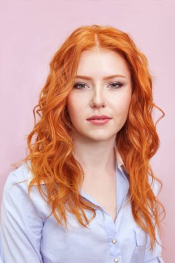 Pembe bir arka plan üzerinde güzel kızıl saçlı kız portresi.