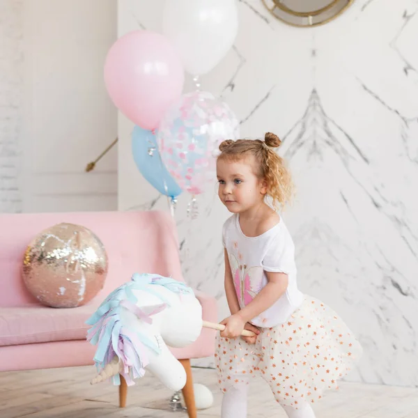 Счастливая Девушка Играет Игрушкой Прыгает Единороге Помещении — стоковое фото