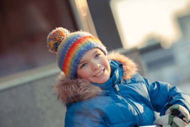 Kışın açık yürüyüş için mavi ceketli mutlu çocuk portresi