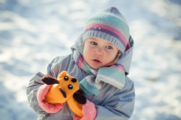 小さなかなり血色の良い女の子の冬の散歩 柔らかいおもちゃで子供が遊ぶ — ストック写真