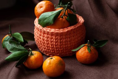 Kahverengi zemin üzerine mandalina ile turuncu örme sepet