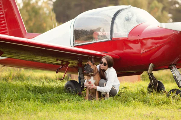 Beautiful girl and dog near airplane. Walk at airport, autumn, outdoor