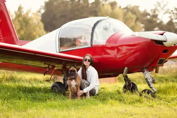 Beautiful girl and dog near airplane. Walk at airport, autumn, outdoor