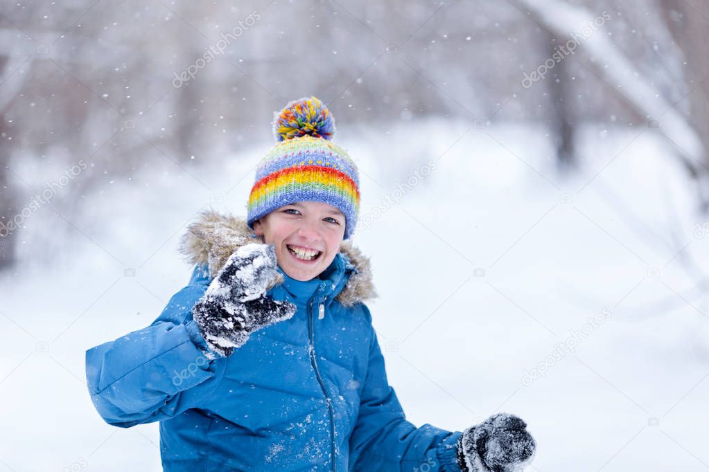 Portrait of cheerful happy boy playing in winter park, outdoor