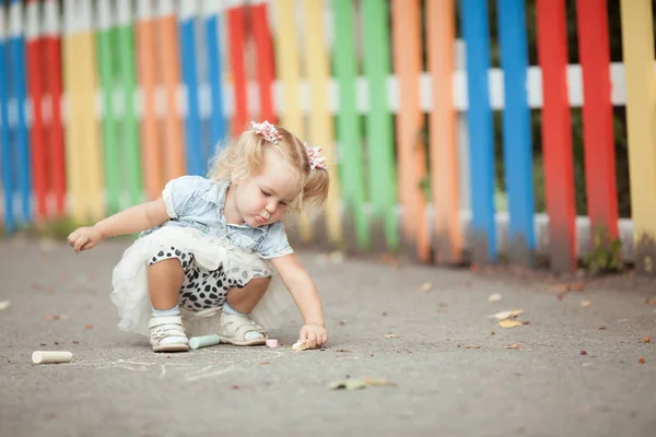 Kleines Hübsches Mädchen Zeichnet Mit Kreide Der Nähe Des Zauns — Stockfoto