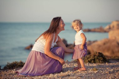 Mutlu güzel anne ve küçük kızı deniz kenarında portresi