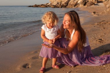 Mutlu güzel anne ve küçük kızı deniz kenarında portresi