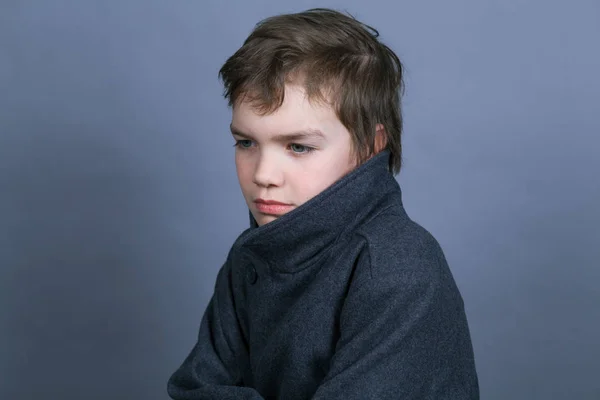 屋内灰色の背景に黒いコートでハンサムな少年のポートレート — ストック写真