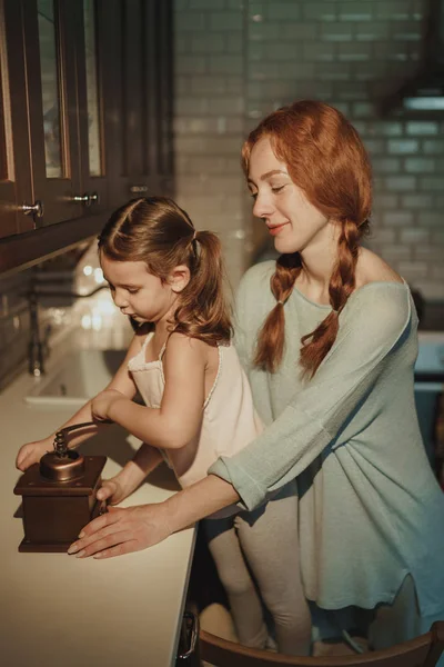 beautiful happy mom and daughter cook in kitchen, indoor